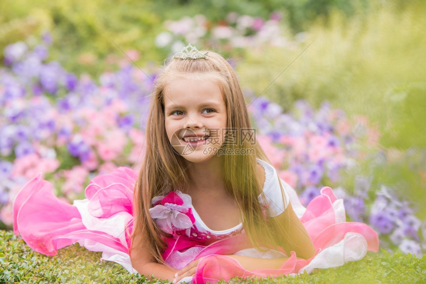 快乐的小女孩穿着粉红裙子在花园里拍照图片