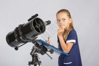 7岁女孩仔细观察天空记录望远镜的观测图片
