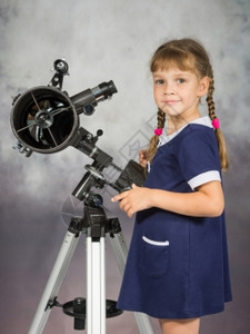 女孩对天文学的热爱站在望远镜旁边查看了框架图片