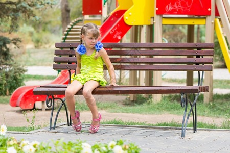 女孩坐在公园椅子上不开心图片