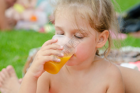 女孩喝果汁从塑料可支配杯子图片
