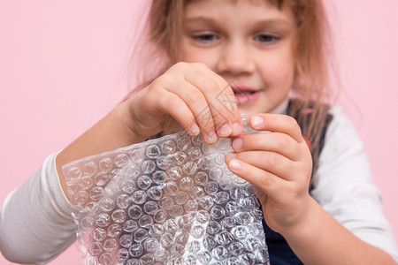 小女孩着捏包装袋上的泡泡球图片