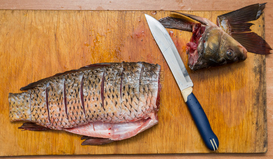 被刷和切开的鱼就在割板上旁边是一把刀图片
