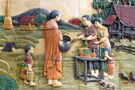 泰国寺庙墙上的土科文化向一名佛教和尚提供食物图片