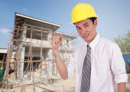 快乐的工程师以举臂庆祝成功的概念房屋建设背景背景图片