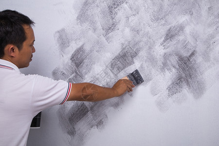 工人用刷子在房屋墙壁上涂彩混凝土图片