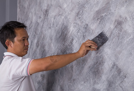 工人用刷子在房屋墙壁上涂彩混凝土图片