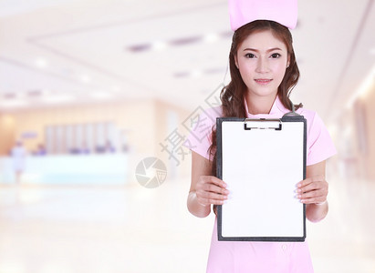 女护士在医院背景中显示空白剪贴板图片