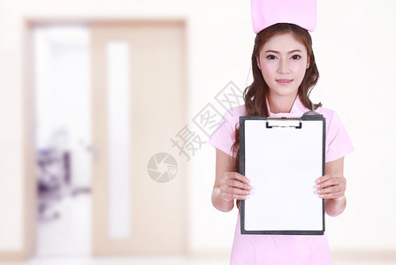 女护士在医院背景中显示空白剪贴板图片