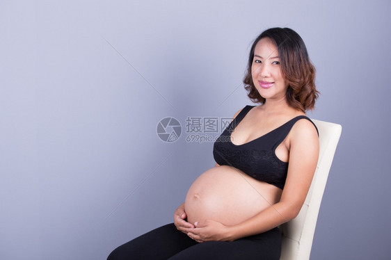 灰色背景上的美丽孕妇图片