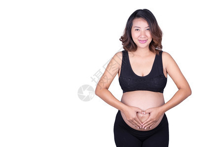 孕妇将双手握在腹部的心脏形状中图片