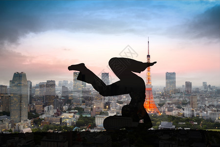 日落时轮廓瑜伽妇女与东京市对面的双接触图片