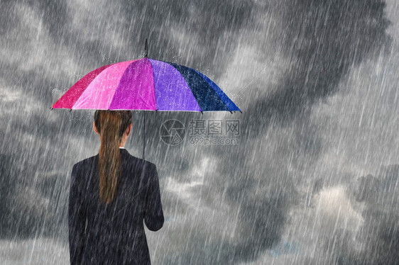拥有多色雨伞的女商人在阴暗的天空下着雨图片