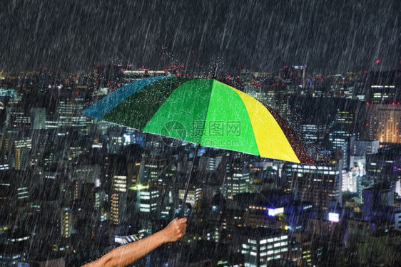 日本东京市背景下着雨手持多彩伞图片