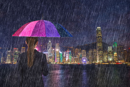 在香港维多利亚港举行多雨雨伞的女商人图片