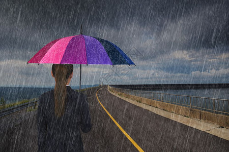 拥有多彩雨伞的女商人在路上下雨图片