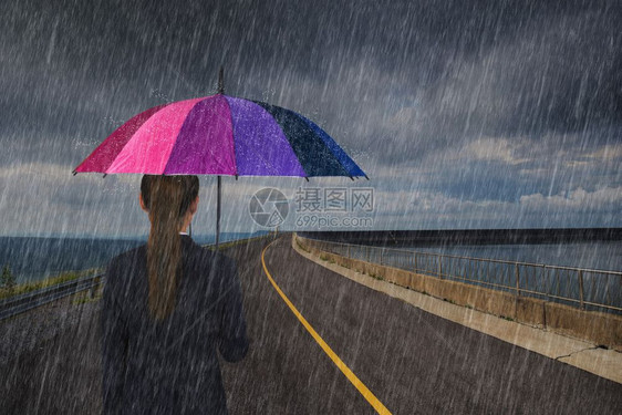 拥有多彩雨伞的女商人在路上下雨图片