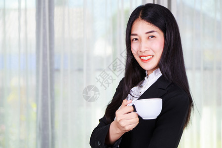 咖啡或茶杯的年轻女商人图片