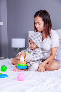 婴儿和母亲在家里睡觉时一起玩具图片