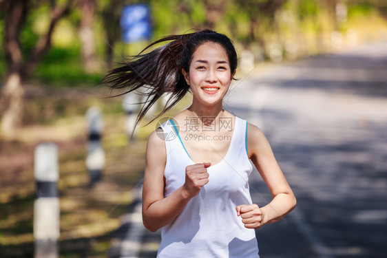 在公园中奔跑的美丽健身女子图片