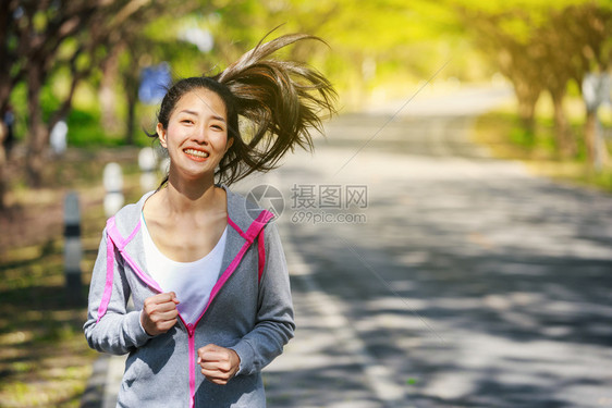 在公园中奔跑的健身妇女图片