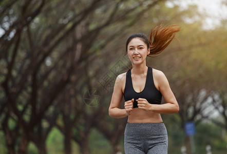 在公园中奔跑的美丽健身女子图片