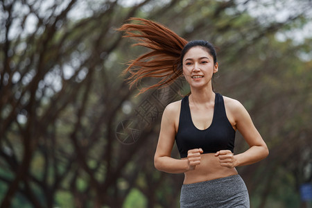 在公园中奔跑的美丽健身女子图片