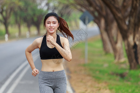 在公园中奔跑的美丽健身女子图片