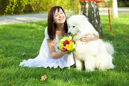带着狗和的新娘坐在草地上图片
