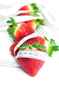 长大多汁红色的熟草莓和测量胶带在白色上隔离图片