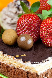蛋糕巧克力和橙色织物上的草莓图片