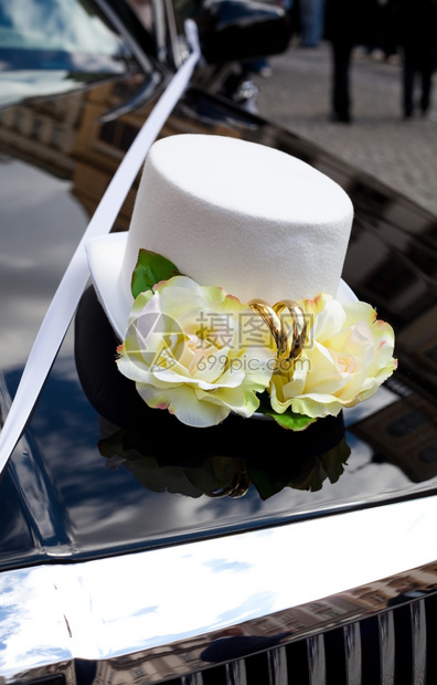 在汽车引擎盖上戴帽子形式的婚礼装饰图片