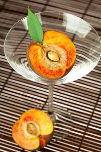 桃子和叶还有竹垫上的马提尼酒杯图片