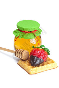密封的蜂蜜和华夫饼上的草莓图片