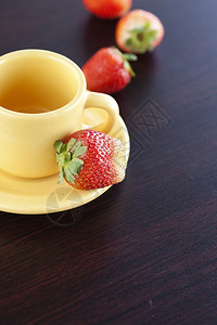 草莓和木制桌上的杯子图片