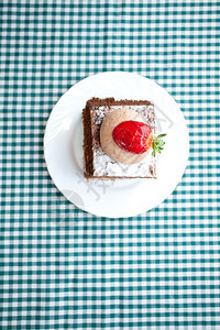 甜美的蛋糕在格形织布上加草莓图片