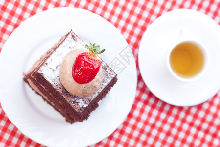 美丽的蛋糕草莓和茶在格布织物上图片