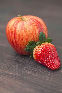 木质表面的多汁苹果和草莓图片