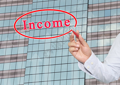 商人用红笔指着收入的文字用指着玻璃窗上面有高楼背景投资和收益的概念图片
