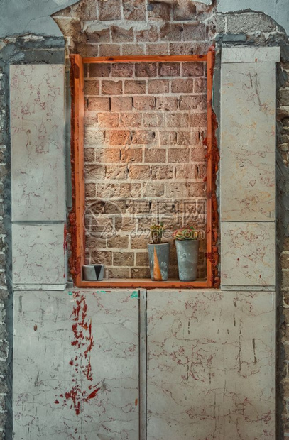在废弃的建筑物中用红砖封住的窗户放在台上的两座陶瓷工厂图片