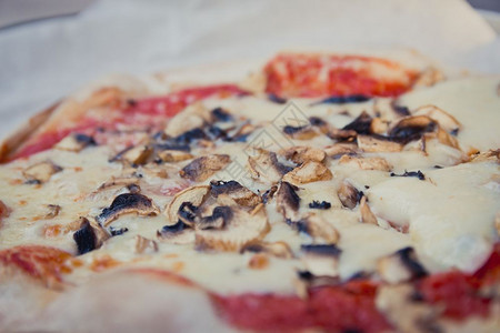 披萨和蘑菇在烘烤纸上图片