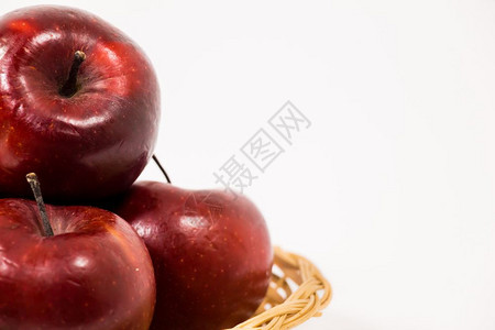 在白色背景中隔绝的维杰篮子里紧贴着成熟的红苹果图片