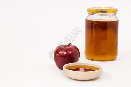 红苹果和一罐蜂蜜孤立在白色背景上的蜂蜜犹太新年的标志RoshHashanah图片