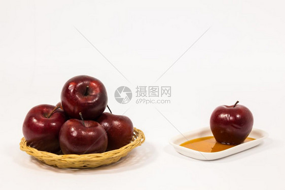 红色苹果和在白盘子上蜂蜜在白色背景上被孤立图片