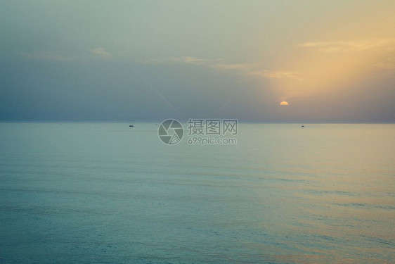 日落在海面上地平线有船只的轮廓图片