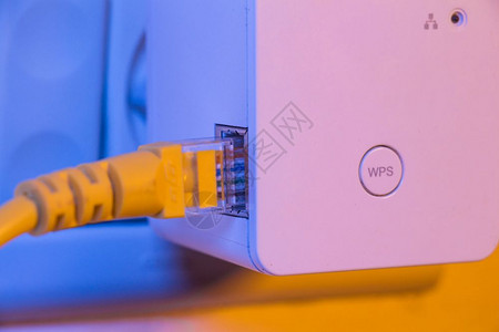 白色电线墙上电插座的无线Fi扩展器插入了Eepernet电缆设备处于接入点模式有助于扩展家庭或办公室的无线网络背景