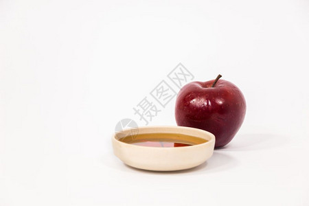 红苹果和一碗蜂蜜孤立在白色背景上犹太新年的标志RoshHashanah图片