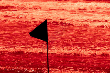 黑色警示旗标着一个美丽的海滩上安全游泳区的极限海滩上有蓝色的天空在Israel有绿海红水恐怖概念图片