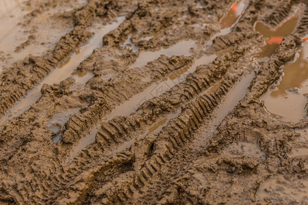 潮湿的棕色泥土和自行车轮胎轨迹的纹理图片