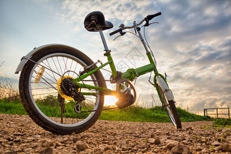 日落时自行车停在泥土路上图片